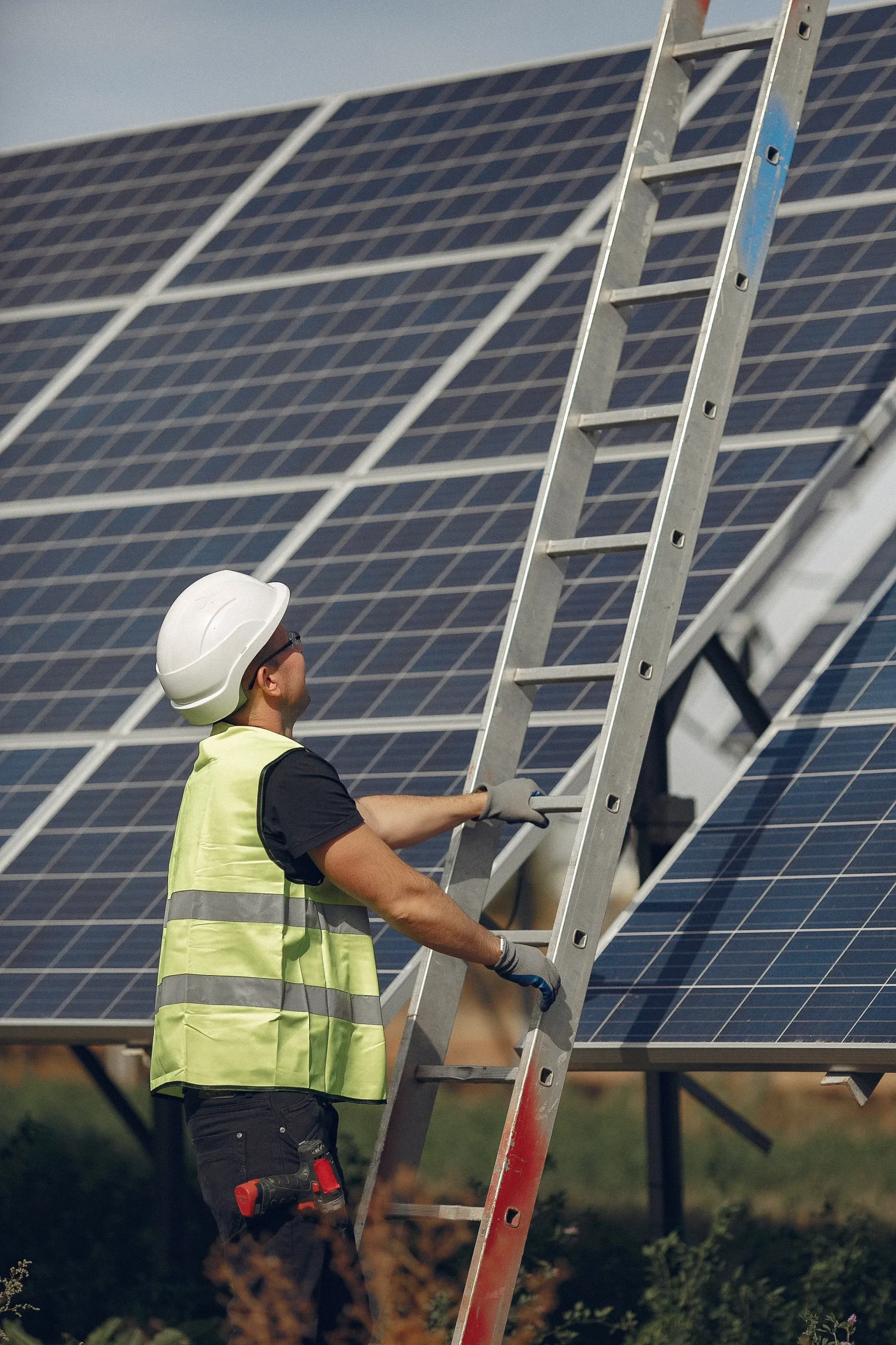 Homem com Capacete perto de um painel solar